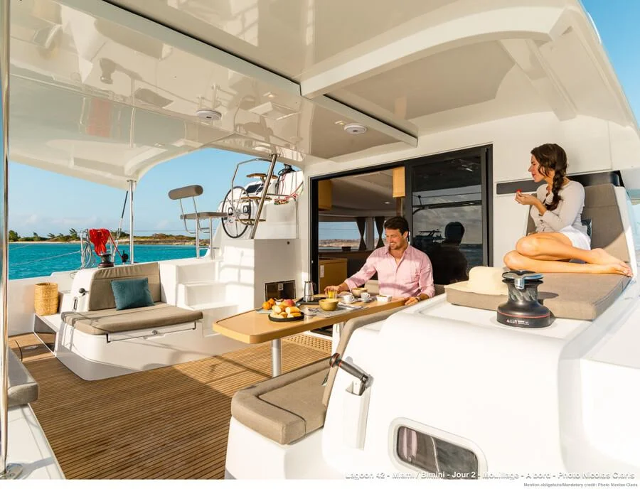 Pareja relajada desayunando en la bañera de popa del Catamarán Lagoon 42